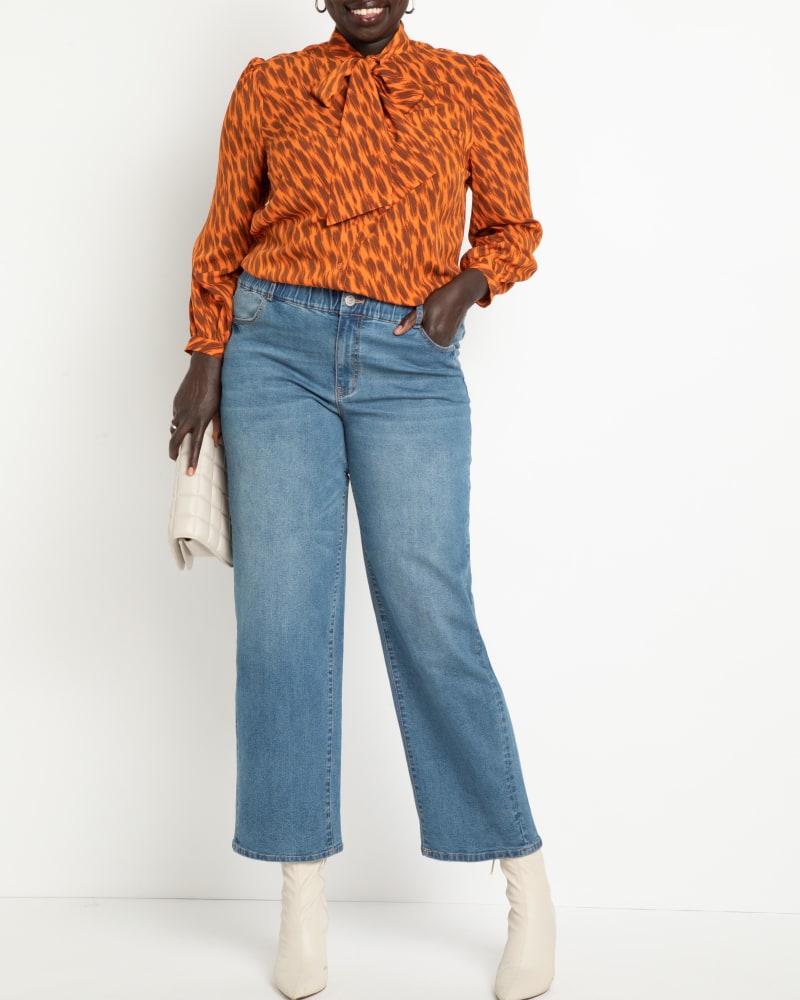 Front of a model wearing a size 14 Kenny Straight Leg Jeans in Medium Wash by ELOQUII. | dia_product_style_image_id:236407